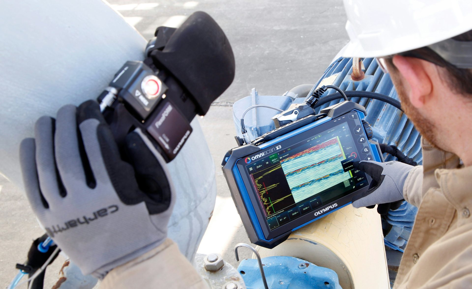 a man in a hard hat is looking at a computer screen